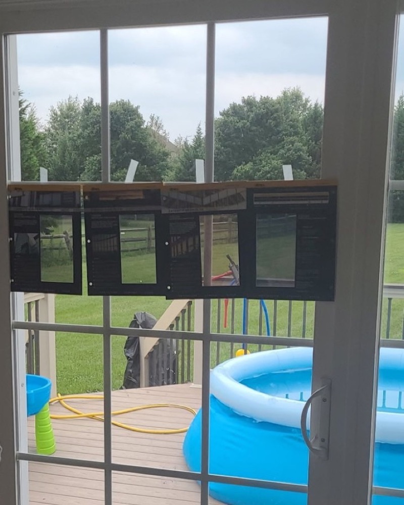 Window film samples taped to a sliding door so the homeowner can compare shades
